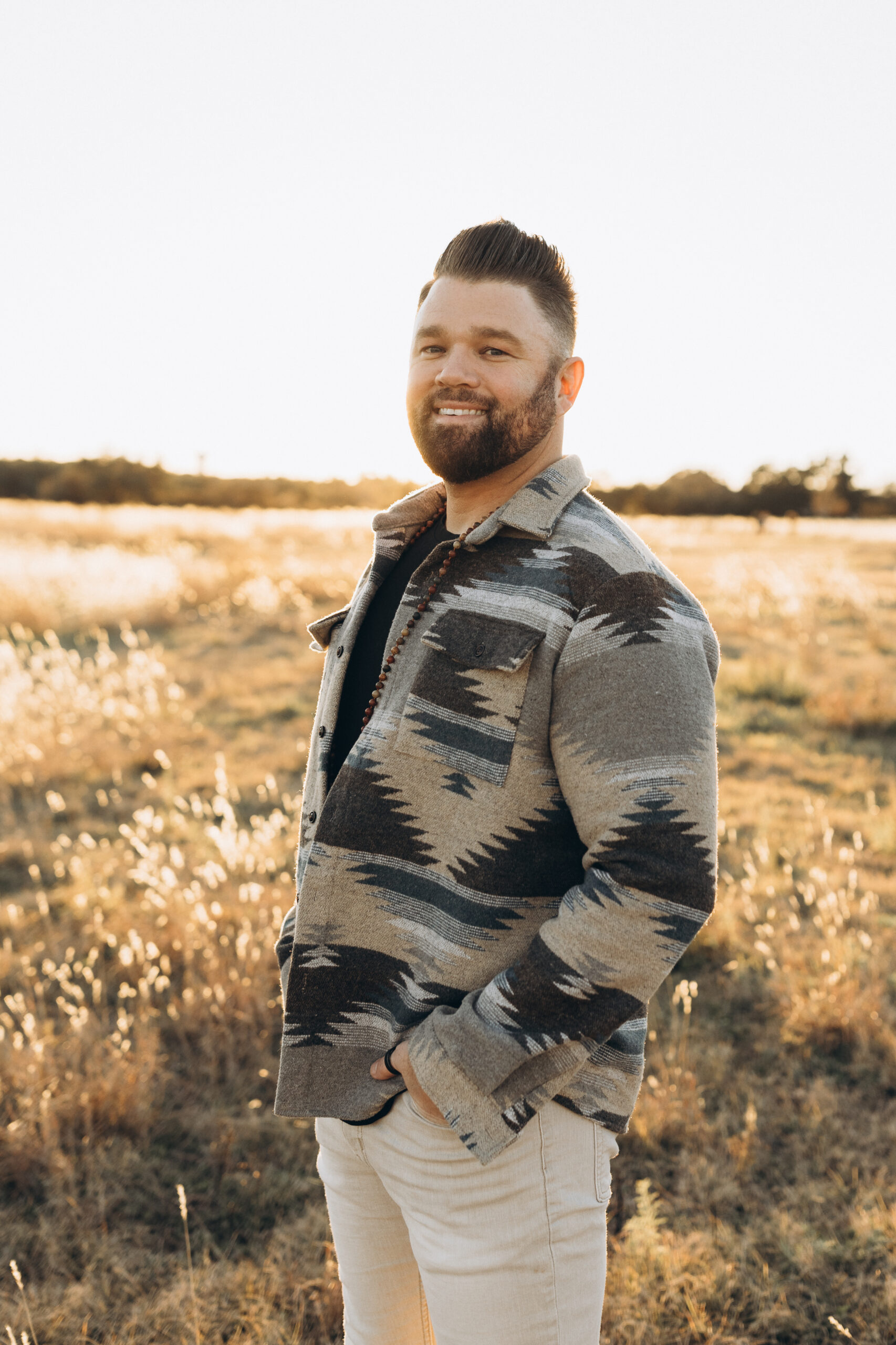 a man josh trent wellness + wisdom podcast standing in a field