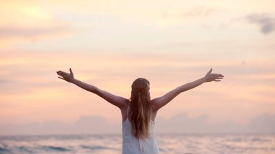 https://www.pexels.com/photo/rear-view-of-woman-with-arms-raised-at-beach-during-sunset-320007/